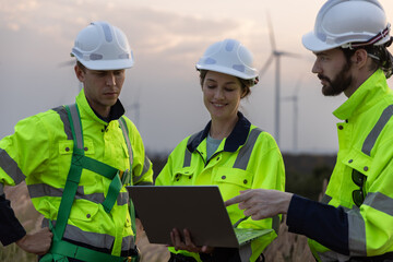 Engineer wearing safety uniform using tablet discussed plan about renewable energy at station...