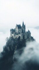 Fototapeta premium Majestic castle perched on a rocky mountain shrouded in mist during early morning hours