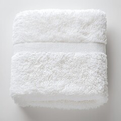 Fluffy white towel neatly folded on a soft surface for a clean and organized aesthetic