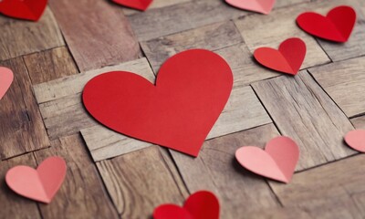 Fototapeta premium Heart-shaped decorations scattered on a wooden surface for Valentine's Day celebration. Valentine’s Day, date, engagement, love, wedding, background