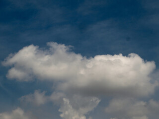 Fototapeta premium Fluffy White Clouds Floating in a Deep Blue Sky – Serene Nature Wallpaper