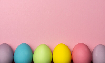 Colorful easter eggs on pink background with copy space for text