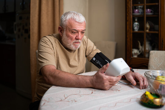 Man checks blood pressure monitor and heart rate monitor with digital pressure gauge. Health care and Medical concept.