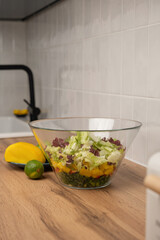 Healthy vegetable salad in a glass bowl on a kitchen countertop