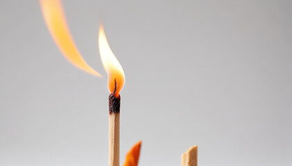 Close-up of a Burning Matchstick Against a Light Grey Background