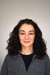 An isolated woman's portrait looking straight forward and smiling