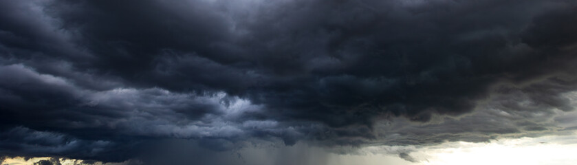 Obraz premium A vast, dark sky filled with heavy, moody clouds foreshadows a powerful windstorm, capturing the dramatic and intense atmosphere of impending turbulent weather.