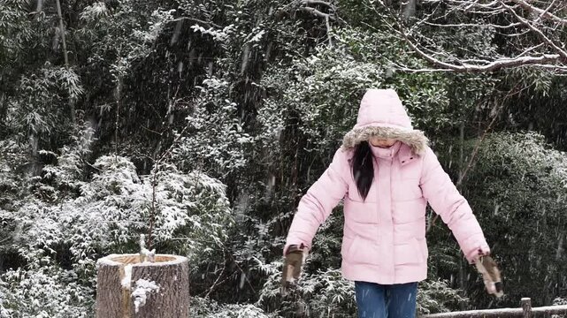冬の公園で楽しく雪遊びしている小学生の女の子の様子
