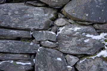 snow covered stone wall in winter