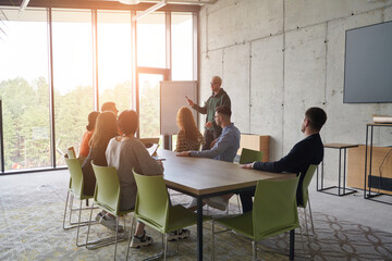 A diverse multiethnic business team engages in a collaborative meeting, discussing strategies and...