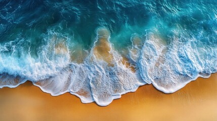 Fototapeta premium Aerial view of ocean waves breaking on sandy beach.