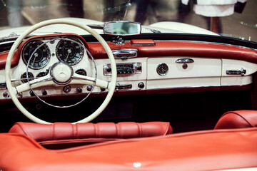 Close up of the dashboard and steering wheel of a vintage car.