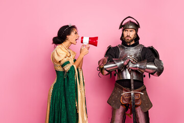 Medieval couple in elegant costumes with pink background showcasing vintage and humorous contrasts
