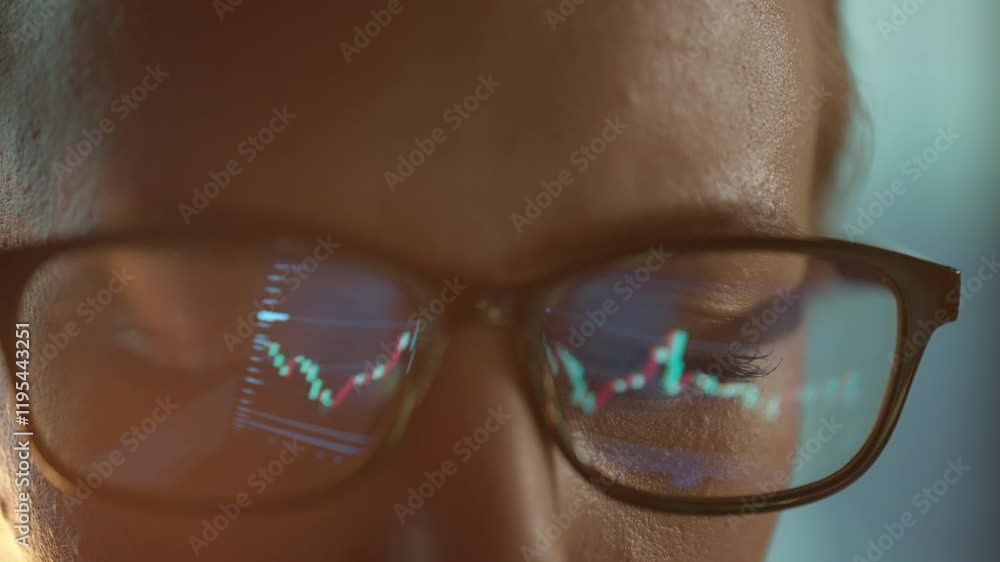 Poster trader wearing glasses is working on laptop computer. screen with stock market charts and bitcoin bt