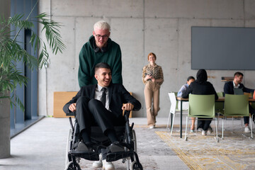 Employee Entertaining Director in a Wheelchair While Rolling Through the Office with Laughter and...