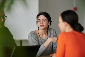 A diverse multiethnic business team engages in a collaborative meeting, discussing strategies and...
