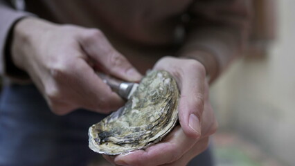 Opening oyster close-up with knife