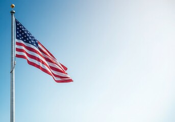 Obraz premium United states flag waving proudly in clear blue sky, representing freedom and patriotism