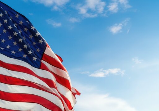 United states flag waving against a blue sky with some clouds