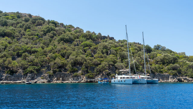 Pleasure boats near Gemiler Island or Saint Nicholas island located off coast of Turkey near city Fethiye or Oludeniz. Byzantine remains of several Greek churches. Gemile in Mediterranean Sea
