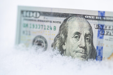 US 100 dollar banknote on the snow