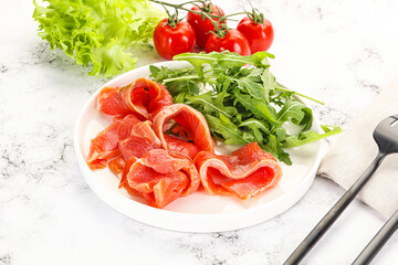 Sliced salmon with fresh arugula