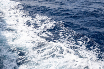 splash of ship water trails cutting through calm sea