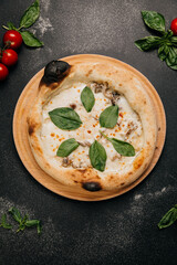 Gourmet white pizza with creamy mozzarella, mushrooms, and fresh spinach on a rustic wooden plate