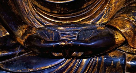 Detail of a Buddha statue doing mudra sit in a lotus position.

