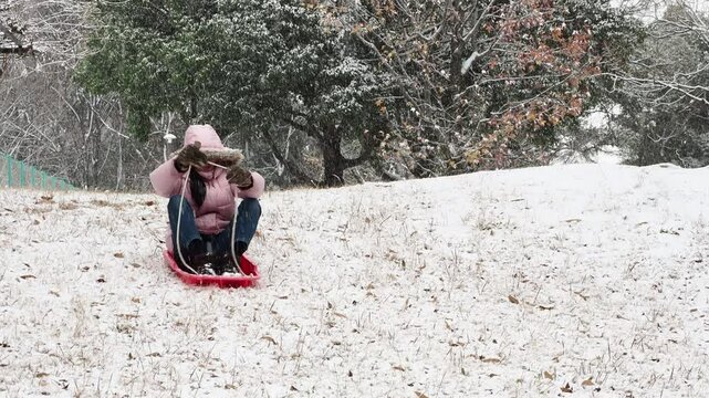 冬の公園で楽しく雪遊びしている小学生の女の子の様子