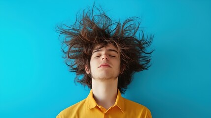 A young person stands against a vivid blue background, their hair standing on end from static electricity, creating a humorous and electrifying effect.