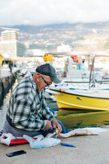 Fishing at sea. A fisherman with his catch. 
Fisherman skinning dogfish he just caught on the seaside.
