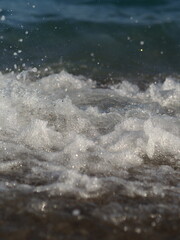 The sea wave runs into the pebble beach. Storm at sea