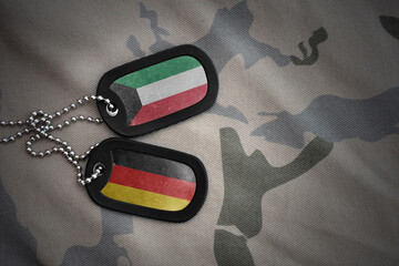 vintage army blank, dog tag with flag of kuwait and germany on the khaki texture background. military concept.