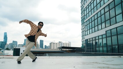 Happy hispanic dancer wears casual outfit break dancing at urban city. Energetic hip-hop performance. Choreographer move along the freestyle beat. Hip hop dancing. Outdoor sport 2024. Hiphop.