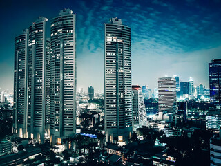 Office building skyscrapers in a big city skyline nighttime Bangkok, Thailand.