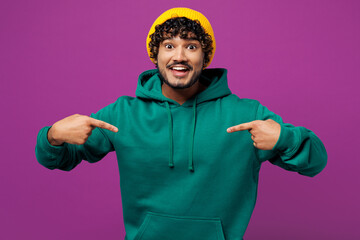 Young shocked surprised overjoyed happy Indian man he wear green hoody yellow hat casual clothes...
