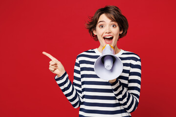 Young surprised woman wear blue striped sweatshirt casual clothes hold in hand megaphone scream...