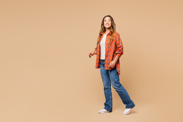 Side profile view young smiling happy cheerful woman she wear orange shirt casual clothes look...
