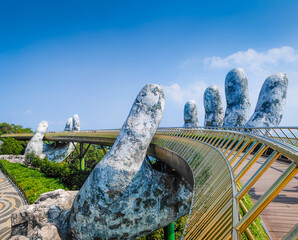 Golden Bridge in Ba Na hills, Da Nang, Vietnam on a sunny day. Lifted by two giant concrete hands. Iconic world famous bridge in the mountains