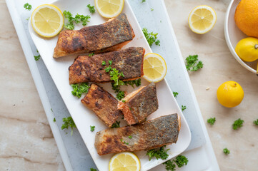 Pan fried salmon fillet with skin on a plate with garnish and lemon fresh and homemade cooked