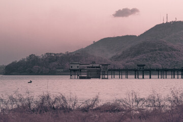 Infrared photography, a serene landscape featuring a body of water with a pier extending out into it