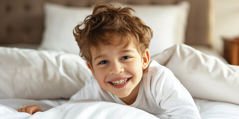 Boy 7 years old smiling while lying in bed in the morning