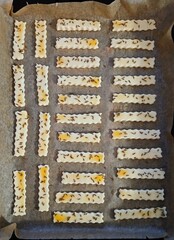 Making savory cumin seed puff pastry. Baking savory sticks. Sprinkling cumin seeds on egg batter
