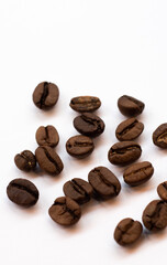 Coffee beans background, artfully scattered on a white background, perfect for coffee-inspired projects.