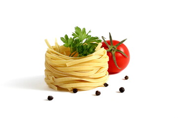 On a white background lies a spaghetti nest and a tomato.