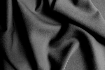 The fabric lies beautifully draped with folds of a bright, rich color.	