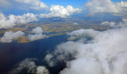 view of the coast with the sea and clouds from a flying airplane