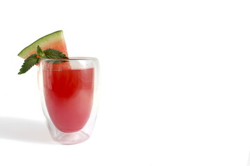 There is a transparent glass with watermelon juice on a white background.