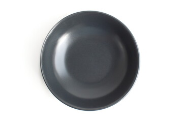 There is a dark grey ceramic empty plate on a white background.